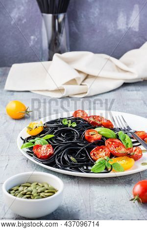Black Spaghetti With Cuttlefish Ink, With Dried Tomatoes, Pumpkin Seeds And Sesame Seeds On A Plate 