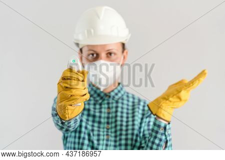 A Female Worker In The Industrial Sector Checks The Temperature With A Digital Thermometer, Selectiv