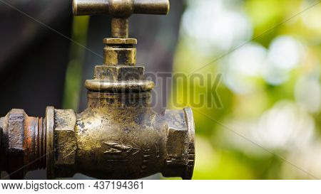 Old Brass Water Tap Isolated On A Light Background. Tap Valve. Old Copper Retro Faucet On A Rusty Pi