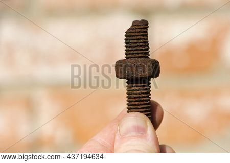 Old Rusty Bolt, Iron Rod With Screw Threads, In Hand. Rusted Mechanical Components. Holding Threaded