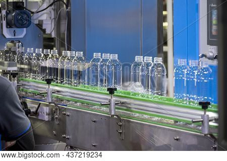 The Empty Pet Bottles  On The Conveyor Belt For Filling Process In The Drinking Water Factory. The H