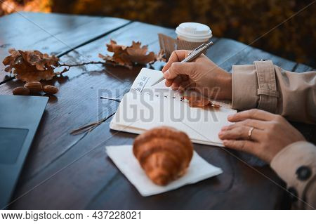 Close-up Of The Hand Of A Cropped Woman Holding Silver Pen And Writing The List To Do In Notepad, Wh