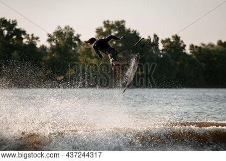 Active Man Making Trick In Jump Time With Wakeboard And Many Splashes Around