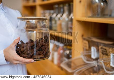 A Woman Holds Croutons In A Glass Jar. Eco Shop Without Plastic Waste.