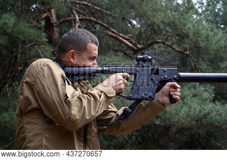 Man with KRISS Vector 9*21 caliber submachine gun in the forest. Unformal shooting range near Kiev. September 6,2021. Kiev Region, Ukraine