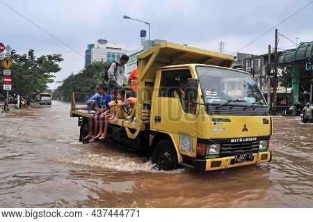 Jakarta, Indonesia - February 4, 2014 : Jakarta Resident Across The Flooding Street On Vehicle In We