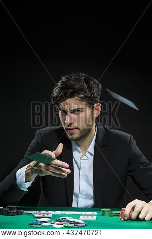 Concentrated Handsome Caucasian Young Pocker Player Throwing Cards To Win At Pocker Table With Chips