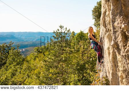 The Girl Climbs The Rock. The Climber Trains On Natural Terrain. Extreme Sport. Outdoor Activities. 