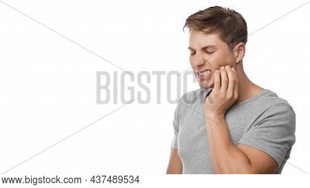 Despaired Millennial European Man Suffering From Toothache, Press Hand To Jaw, Show Displeasure