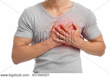 Young Caucasian Guy Suffering From Pain In Chest, Presses Hand To Sore Spot, Indicated In Red
