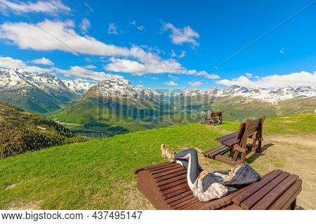 Woman Resting On A Bench On Top Of Muottas Muragl Station Of The Famous Funicular Railway In Switzer