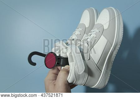 Buying New Sneakers. Copy Spce. Male Hand Holding A Pair Of New Teenage Leather Sneakers