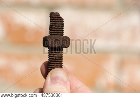 Old Rusty Bolt, Iron Rod With Screw Threads, In Hand. Rusted Mechanical Components. Holding Threaded