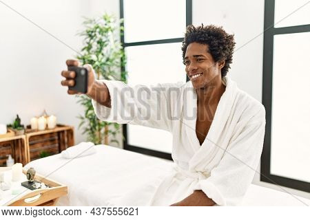 Young african american man smiling confident make selfie by the smartphone at beauty center