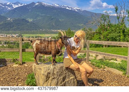 Tourist Girl Playing With A Goat In Maienfeld Village. Deutch Switzerland Of Graubunden Canton Or Gr