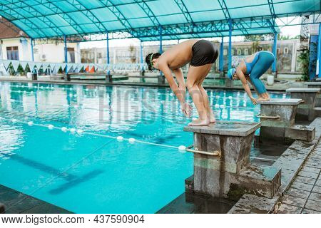 Some Athletes Stand On The Blockboard In A Position To Jump And Swim