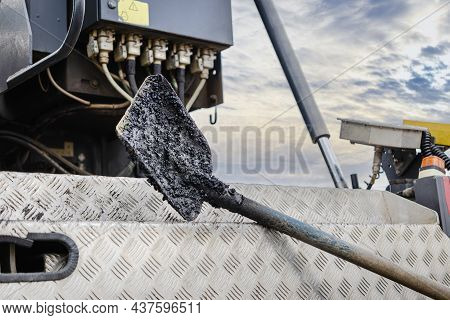 Construction Tool For Road Works. Shovel For Laying Asphalt Close-up Lies On The Asvalt Laying Machi