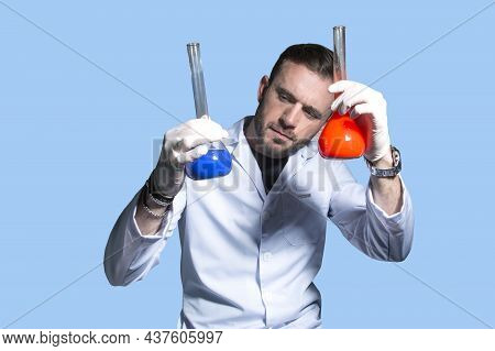 Male Doctor Biologist In A White Coat Compares Two Dangerous Biological Samples Of A New Strain Of C