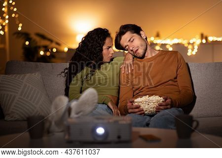 Discontented Wife Watching At Sleeping Husband Watching Movie At Home