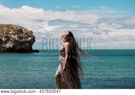 Girl With Long Hair Posing In Water. Treavel By The Sea