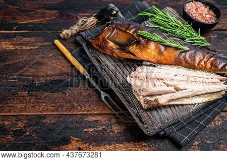 Cut Hot Smoked Fish On A Wooden Board With Rosemary. Dark Wooden Background. Top View. Copy Space