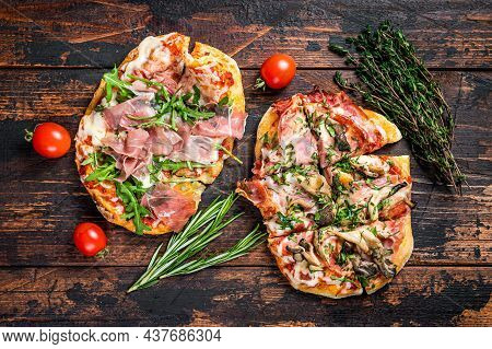 Sliced Pizza With Prosciutto Parma Ham, Arugula And Parmesan Cheese. Dark Wooden Background. Top Vie