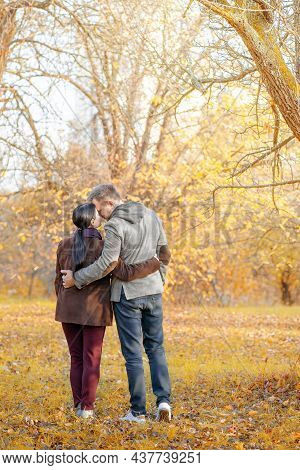 Autumn Caucasian Couple Standing Face-to-face In A Park Full Of Sun. Casual Style In Autumn Colors. 