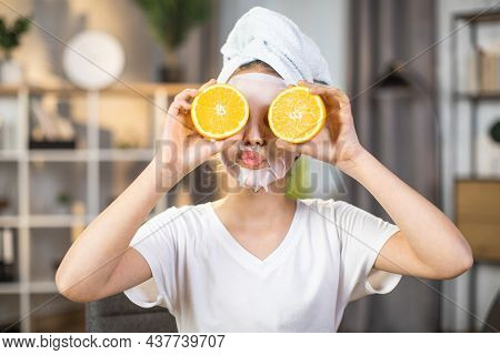 Pretty Female Teenger With Towel On Head And Mask On Face Covering Eyes With Slices Of Oranges. Mine