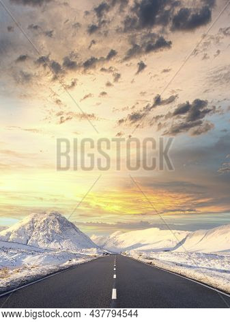 Buachaille Etive Mor Mountain And Empty Road Covered In Snow During Winter