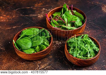 Mix Salad Leafs, Arugula, Spinach And Swiis Chard In Wooden Bowls. Dark Background. Top View