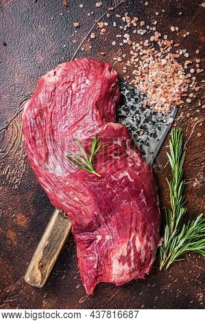 Flap Or Flank Raw Beef Meat Steak On A Butcher Cleaver With Herbs. Dark Background. Top View