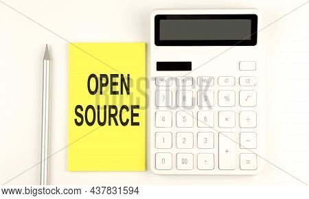 Text Open Source On Yellow Sticker, Next To Pen And Calculator