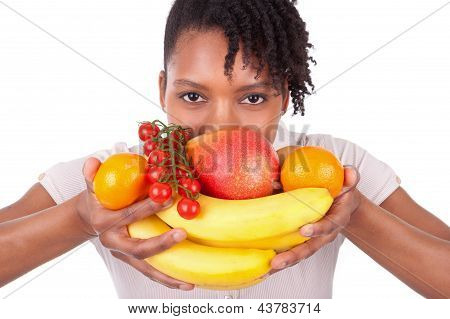 Nuori iloinen musta / afroamerikkalainen nainen, jolla tuoreita hedelmiä