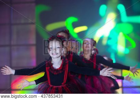 Little Girls Are Performing A Dance Number. Dance For Helovinna In Red Suits. Girl Dancing. Emotiona