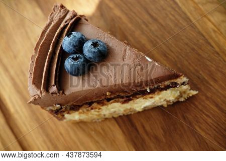 Piece Of Kiev Cake With Chocolate Icing And Blueberries. Top View