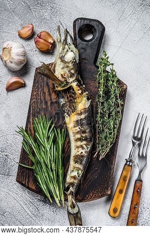 Cooked Mackerel Icefish On A Wooden Cutting Board. Black Background. Top View