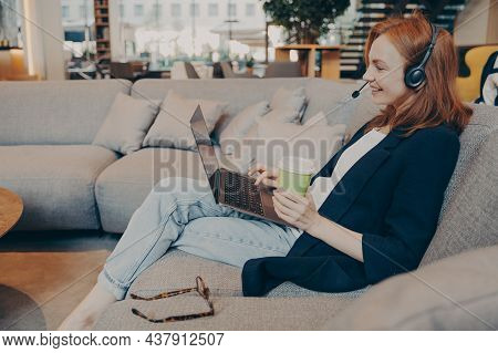 Side View Of Young Smiling English Teacher Having Video Call With Students On Laptop, Working Online