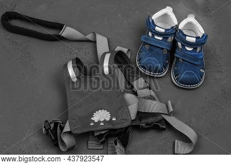 Baby Leading Strings And Orthopedic Shoes. The First Steps Of The Child. Protect The Child From Fall