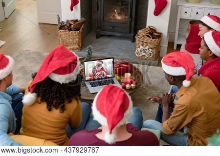 Diverse group of friends making laptop christmas video call with senior man in santa costume. christmas, festivity and communication technology.