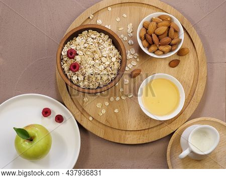 Oat Flakes, Raspberries, Almonds, Honey On A Wooden Background. Milkman, Walnuts, Green Apple. The R
