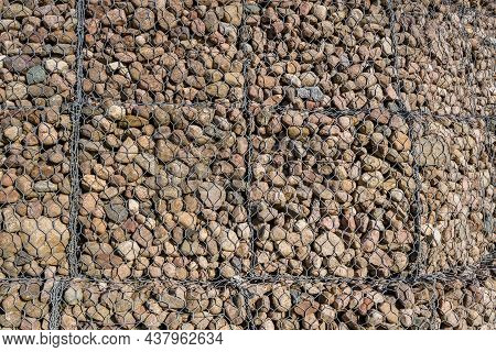 Engineering Structure Made Of Stones Behind Metal Wire Netting To Strengthen The River Bank Near The