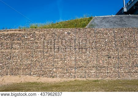 Engineering Structure Made Of Stones Behind Metal Wire Netting To Strengthen The River Bank Near The