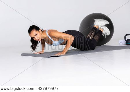 Fit Gemale Does Pushups On Mat In Sportswear On White Background, Trainer Show Exercise And Stretch 
