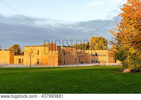 School Building And Schoolyard In Sunny Evening During Sunset In Fall.