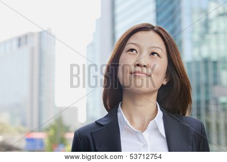 Smiling young businesswoman looking away