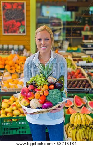 a young woman buying fruits and vegetables at a weekly market. healthy diet.