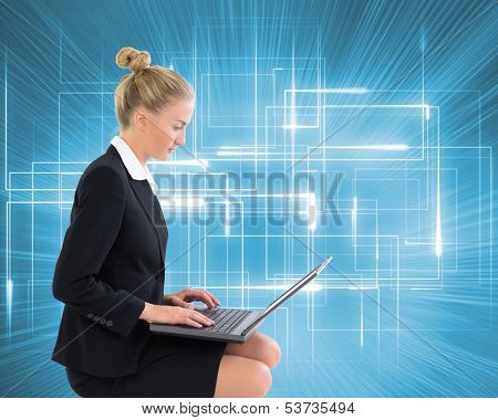 Composite image of blonde businesswoman using laptop