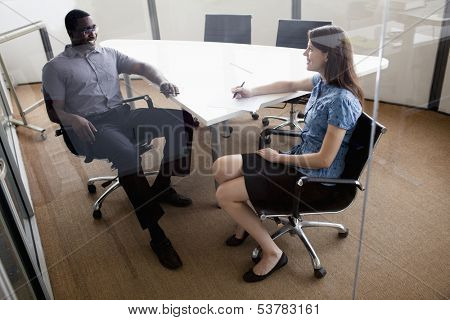 Two business people sitting at conference table and discussing during business meeting