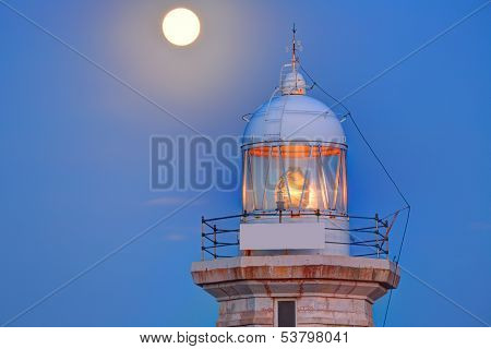 Ciutadella Menorca Punta Nati lighthouse with moon shining in sky