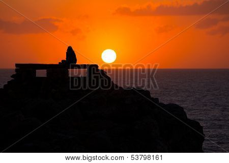 Ciutadella Menorca at Punta Nati orange sunset with girl backlight